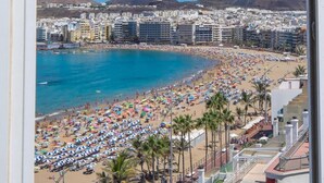 Un paisaje costero con playa, edificios y montañas.