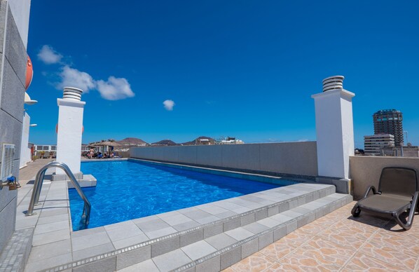 Piscine extérieure, parasols de plage, chaises longues