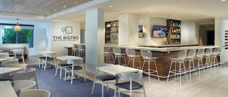 A modern bistro with a bar area, seating arrangements, and a visible menu board.