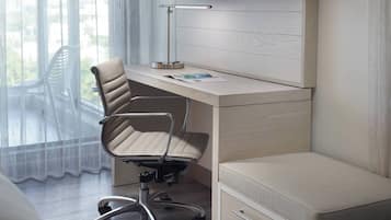 Un espacio de oficina moderno con escritorio, silla y una cama pequeña.