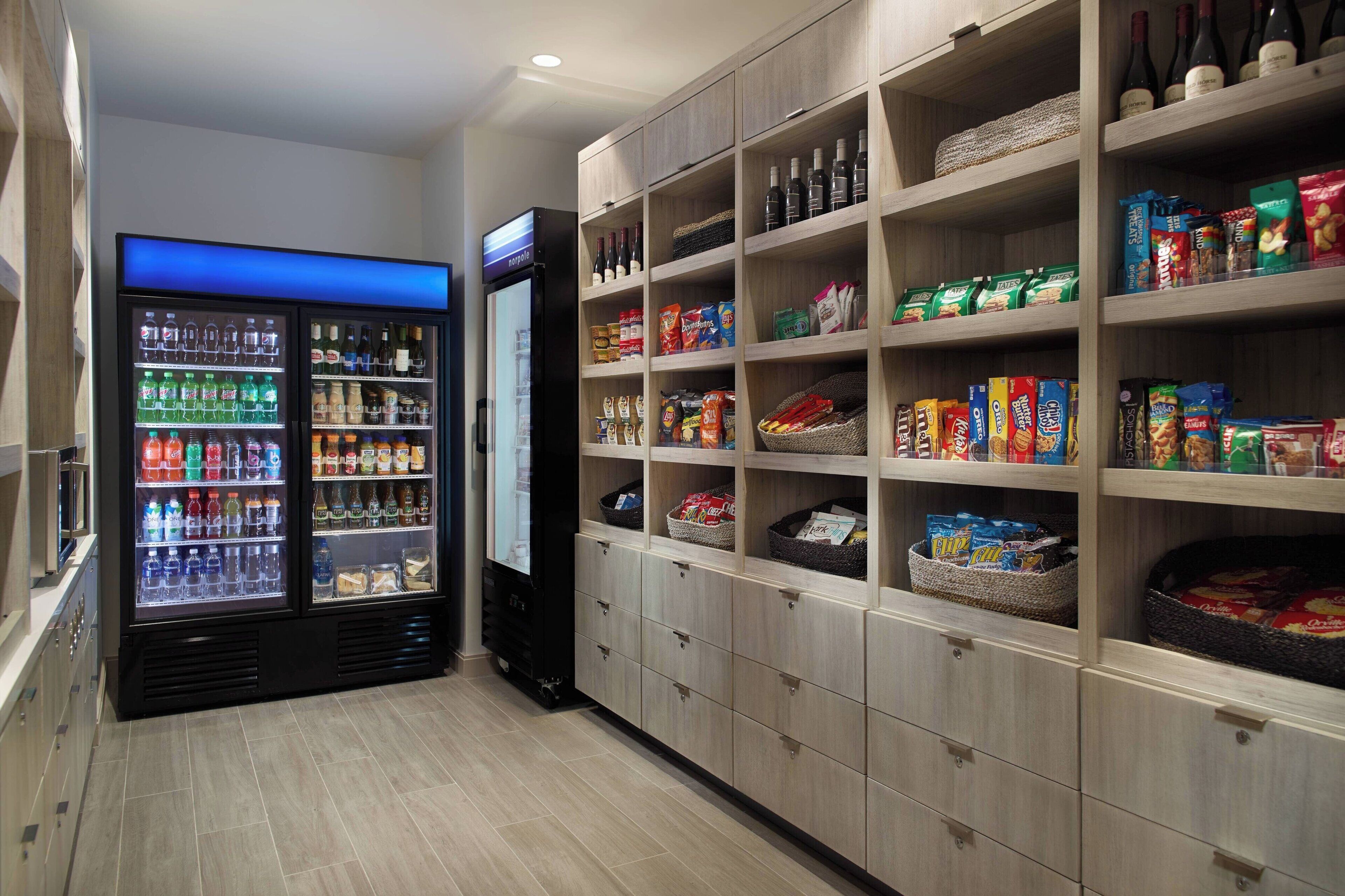 Un garde-manger d’hôtel avec des étagères remplies de collations, de boissons et de condiments.