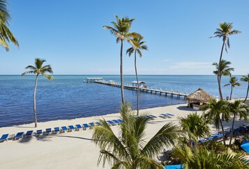 Praia particular, espreguiçadeiras, guarda-sóis, toalhas de praia 