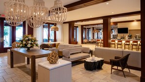 A spacious lobby with a seating area, a bar, and a large window providing a view of the outdoors. - Cheeca Lodge & Spa (Islamorada)