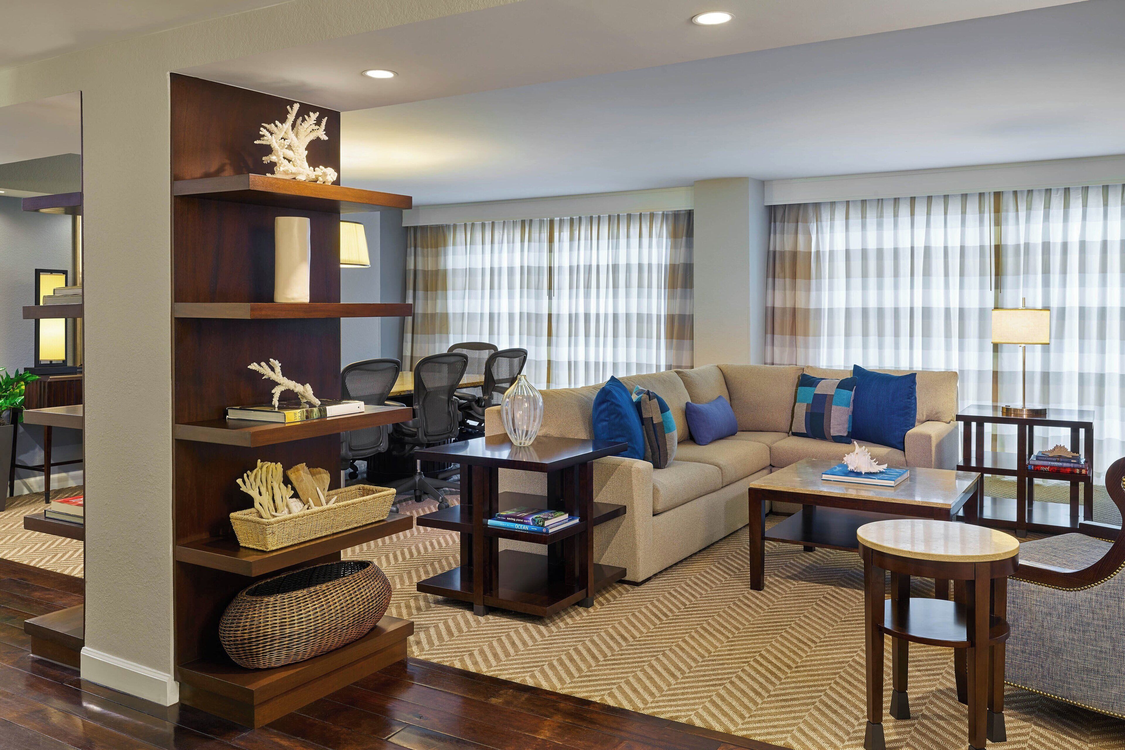 A modern living room with a sofa, coffee table, and a bookshelf.
