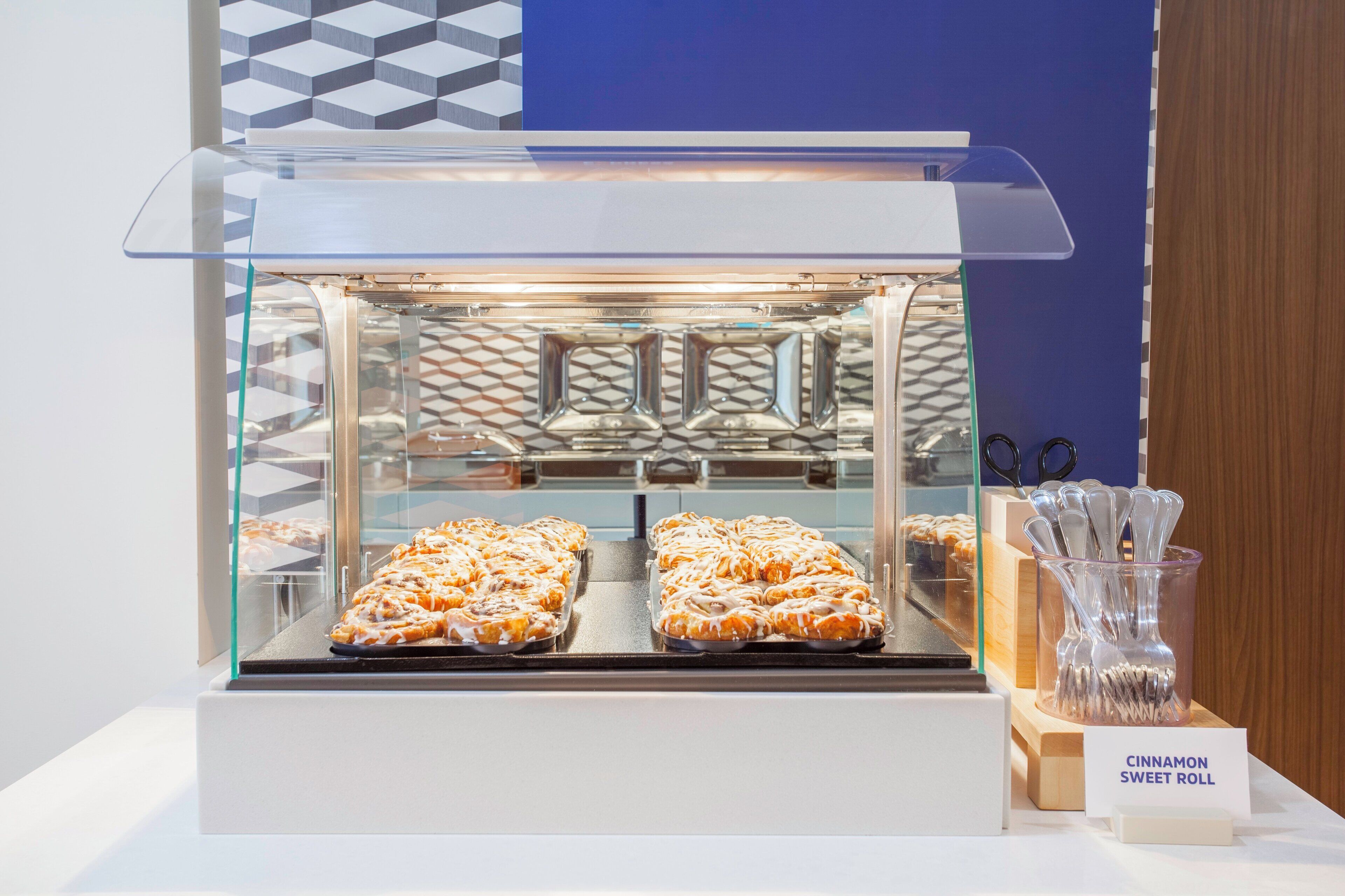 A bakery display case with cinnamon sweet rolls.