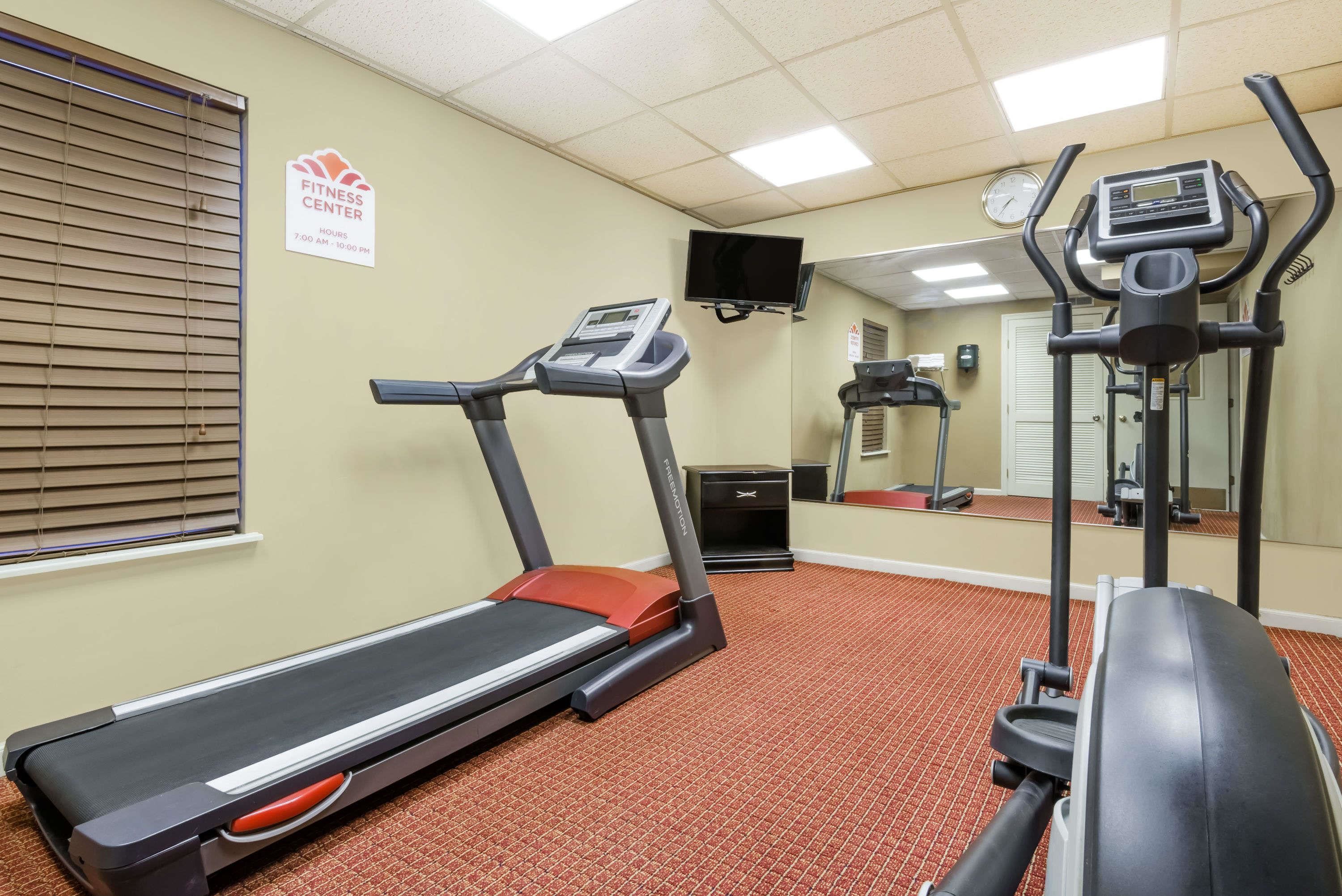 A fitness center with treadmills, a stationary bike, and a mirrored wall.