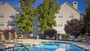 A swimming pool with lounge chairs and a no diving sign, surrounded by trees and a building. - Sonesta ES Suites Cincinnati - Sharonville East (Sharonville)
