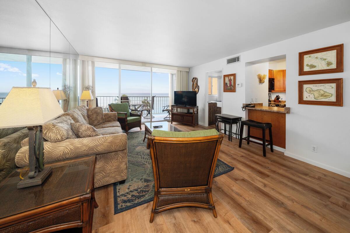 A spacious living area with a balcony, a television, and a dining area.