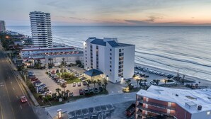 Un hotel frente al mar con varias dependencias, aparcamiento y vistas al océano.