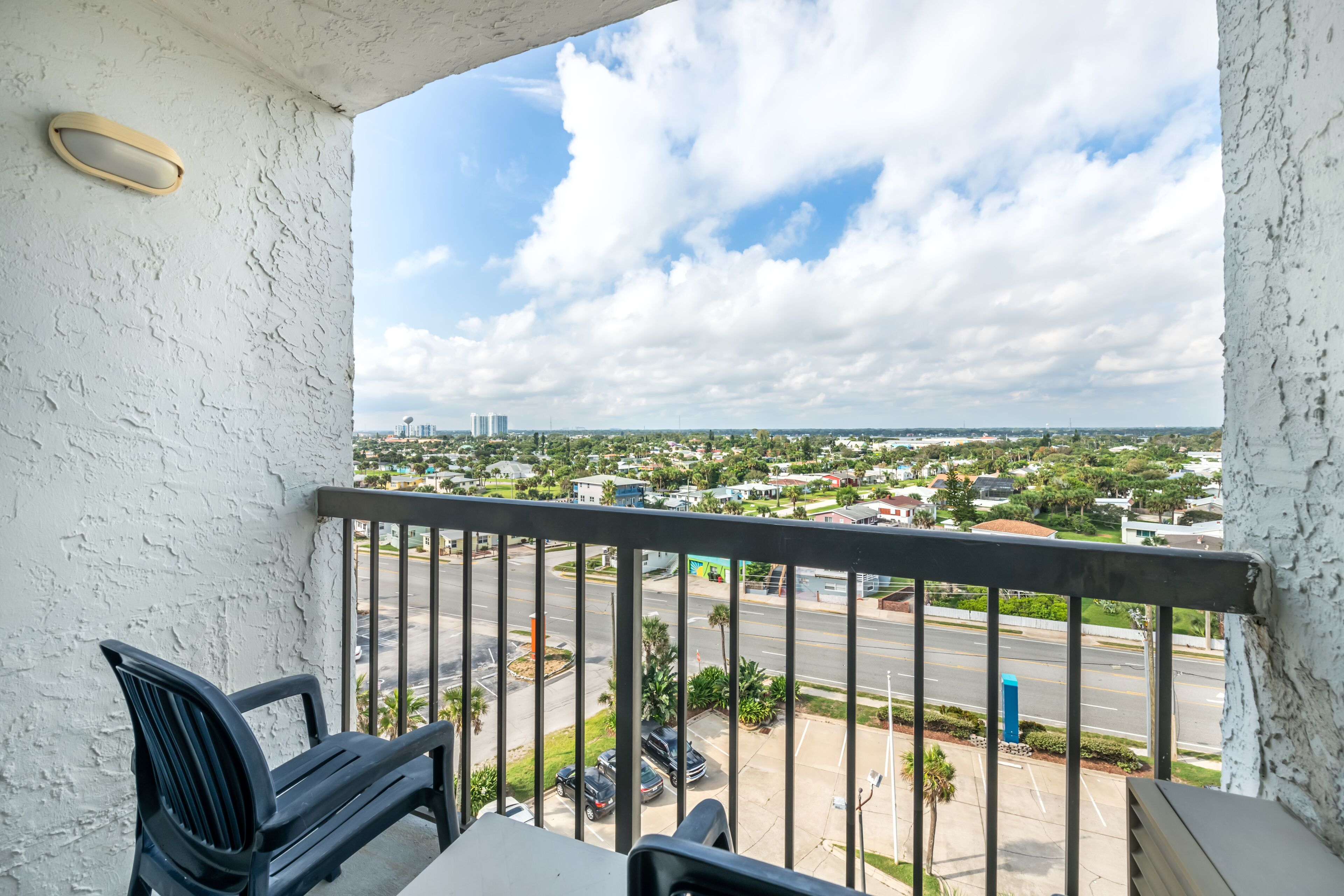 Un balcon donnant sur un paysage urbain, une chaise et une table.