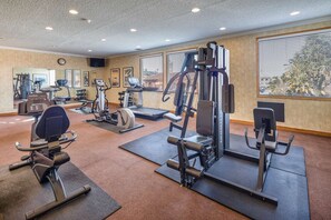 A gym with various exercise equipment, including treadmills, weight machines, and a stationary bike.