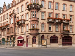 Un edificio histórico con varios balcones, ventanas amplias y un restaurante en la planta baja.