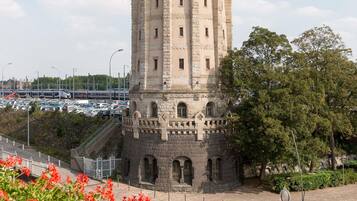 A stone tower with arched windows and a staircase leading up to a balcony.