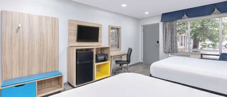 A hotel room with two beds, a desk with a chair, a TV, a wardrobe, and a window with curtains.