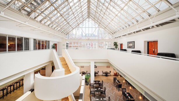 A spacious atrium with a high ceiling, a central spiral staircase, and multiple seating areas. - Millennium Hotel London Knightsbridge (London)