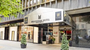 The Millennium Hotel entrance with a modern facade, large glass windows, and potted plants. - Millennium Hotel London Knightsbridge (London)