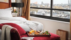 A hotel room with a bed, breakfast tray, and a window with a city view. - Millennium Hotel London Knightsbridge (London)