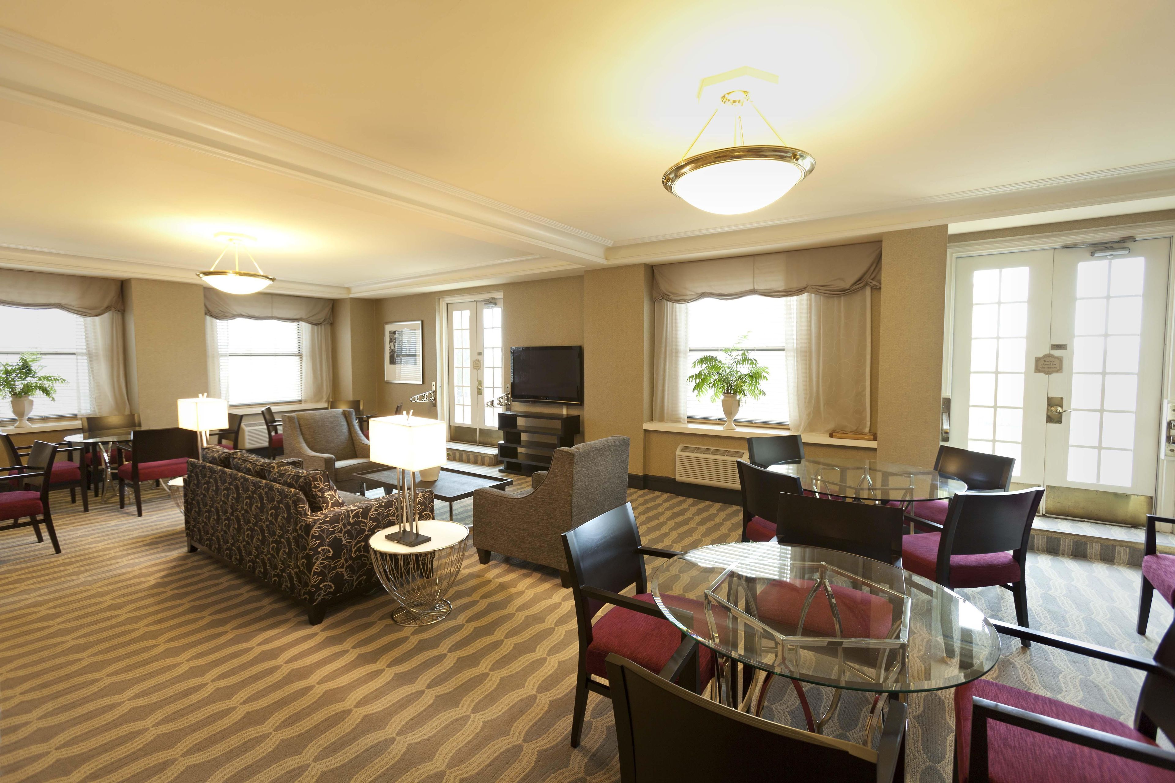 Une chambre d’hôtel comprenant un coin salon, une table à manger, des chaises, des canapés, un téléviseur et une cheminée.