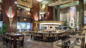 A hotel lobby with a bar area, seating arrangements, and decorative elements.