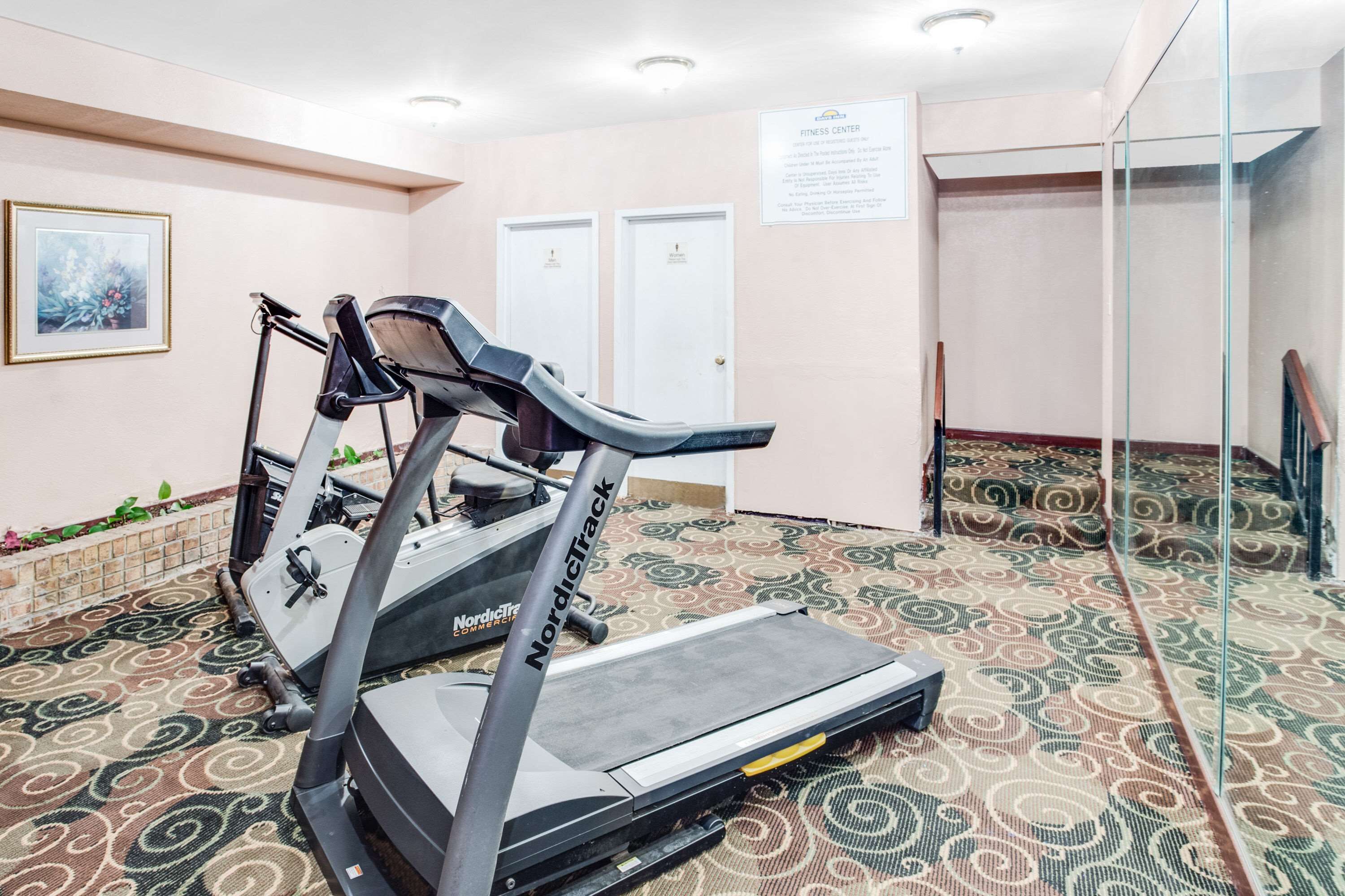 Un gimnasio con cintas de correr y una alfombra estampada.