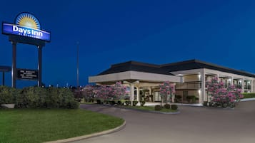 Un hotel Days Inn con un letrero llamativo, un estacionamiento y jardines bien cuidados.