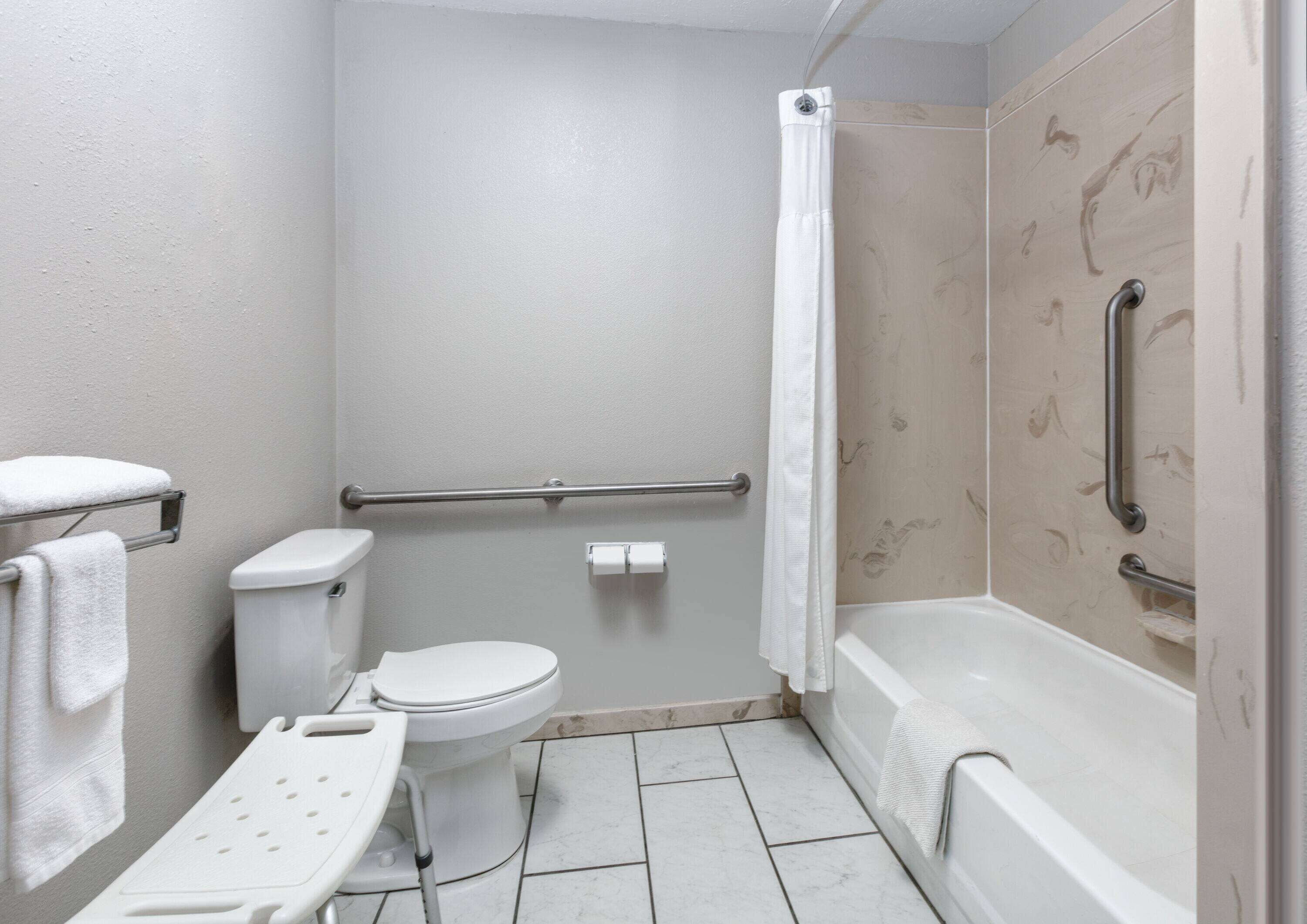 A small, modern bathroom with a toilet, bidet, and bathtub.