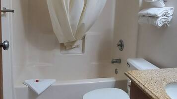A bathroom with a shower, toilet, and sink.