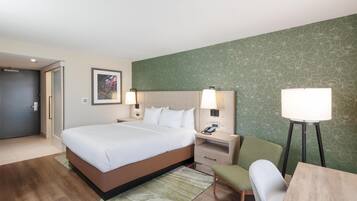 Een hotelkamer met een bed, nachtkastjes, een bureau en een stoel.