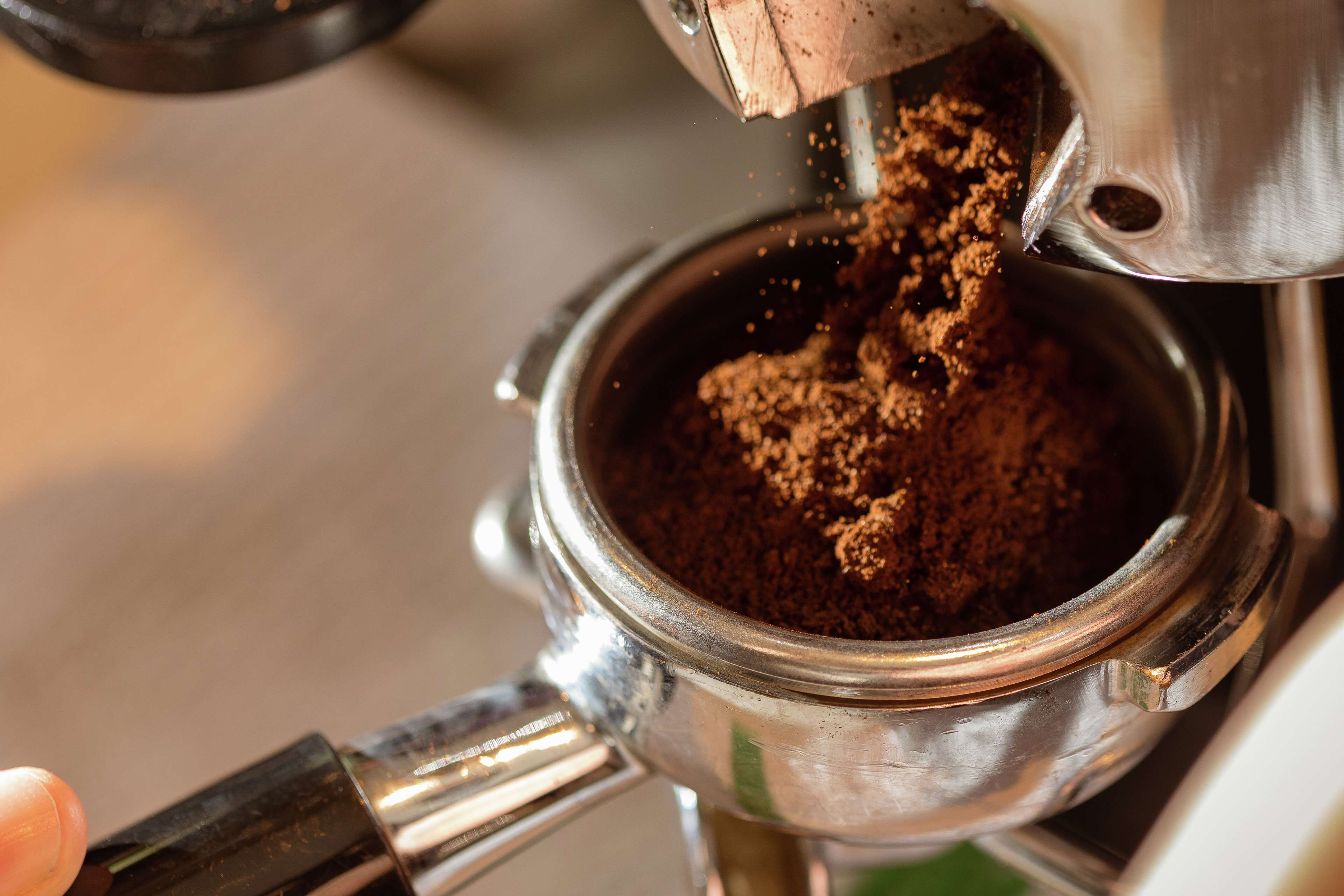 A close-up of a coffee machine dispensing ground coffee.