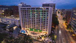 A multi-story hotel with a swimming pool and outdoor seating area.