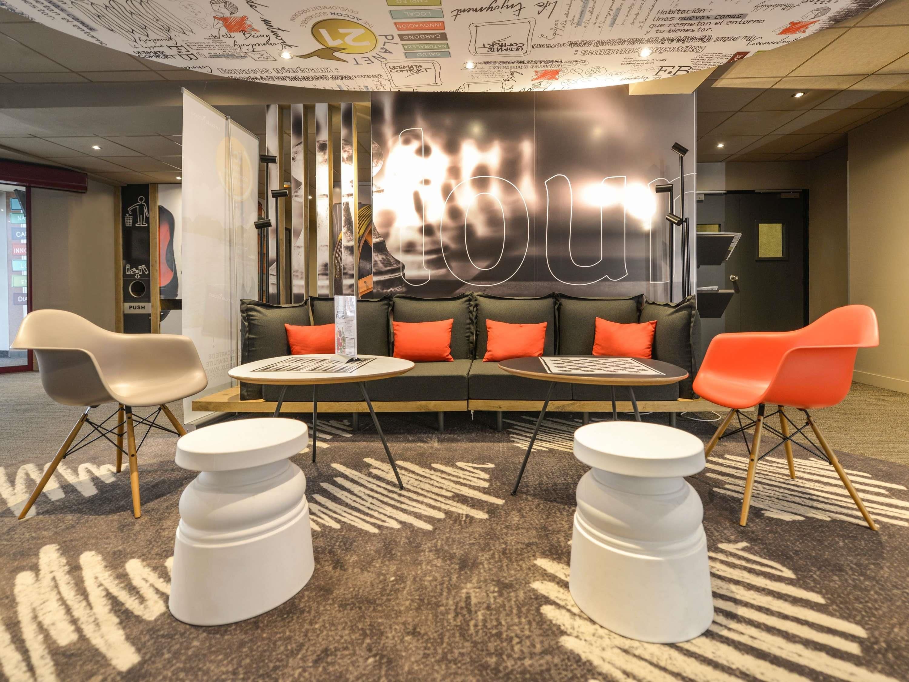 A modern lounge area with a sofa, two chairs, and a coffee table.