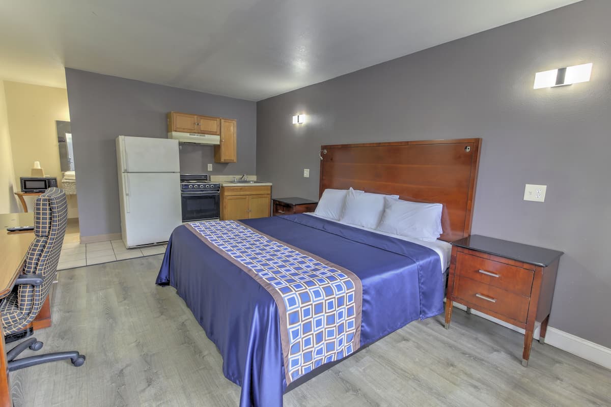 A bedroom with a bed, bedside table, and a small wooden nightstand.