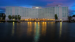 Un hotel gran i modern amb un cartell ben visible que diu "Grand Bay", amb façana simètrica, múltiples pisos i ubicació al passeig marítim.