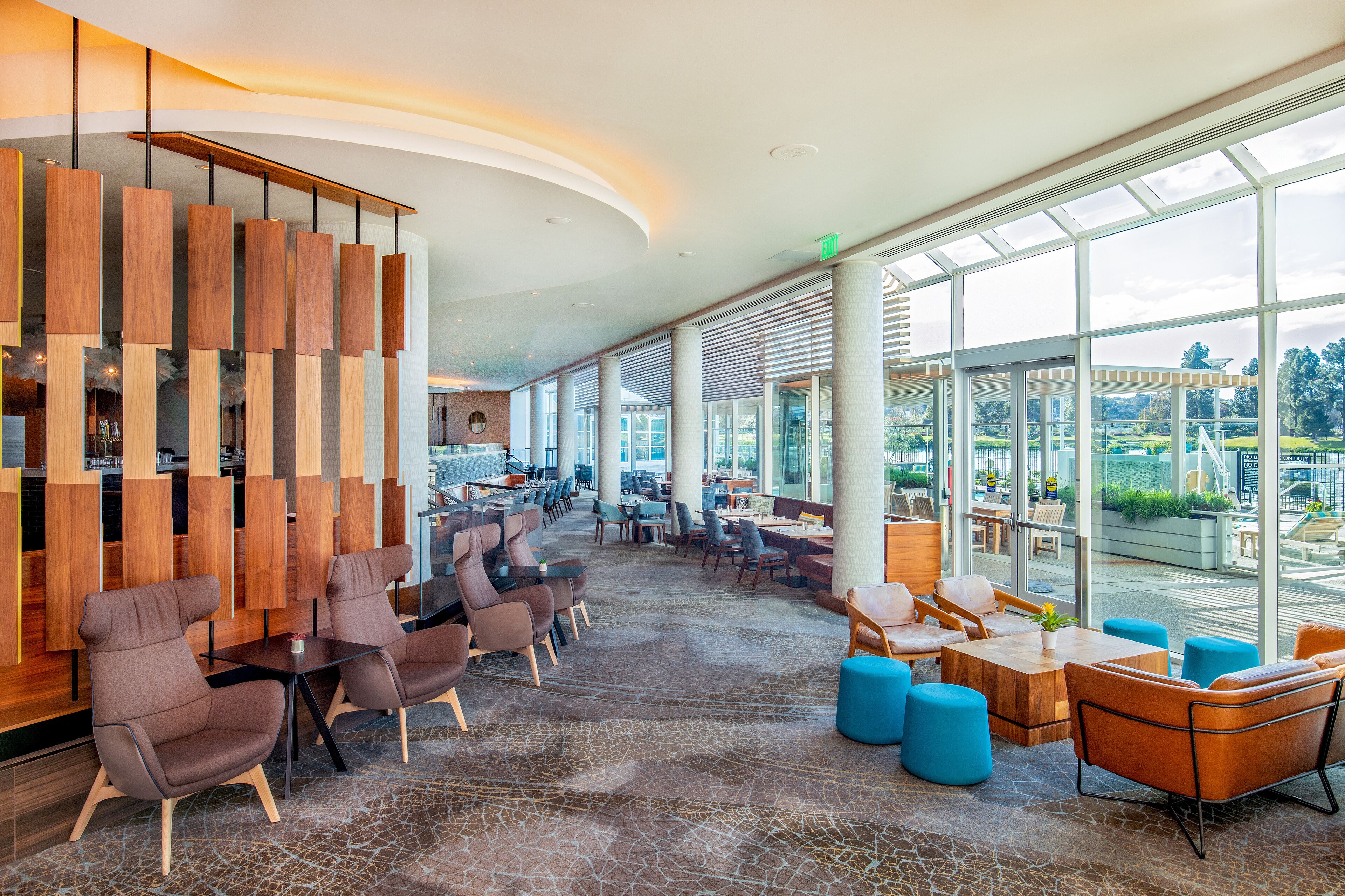 A spacious indoor area with seating arrangements and large windows offering a view of the outdoors.