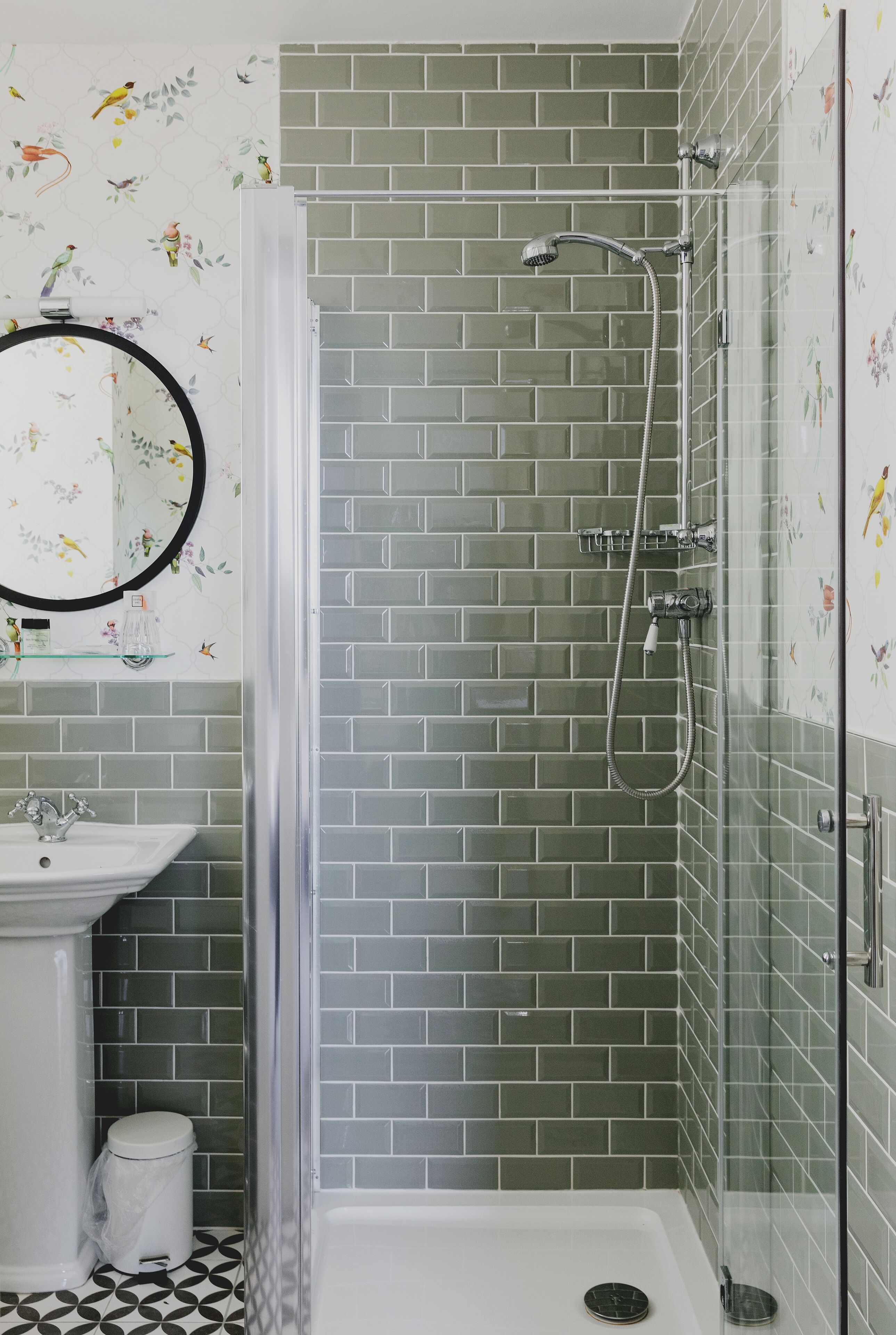 A bathroom with a shower, a sink, and a toilet.