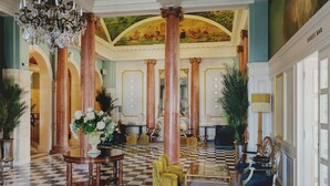 A grand lobby with high ceilings, ornate columns, and a checkered floor. - The Queens Hotel (Portsmouth)