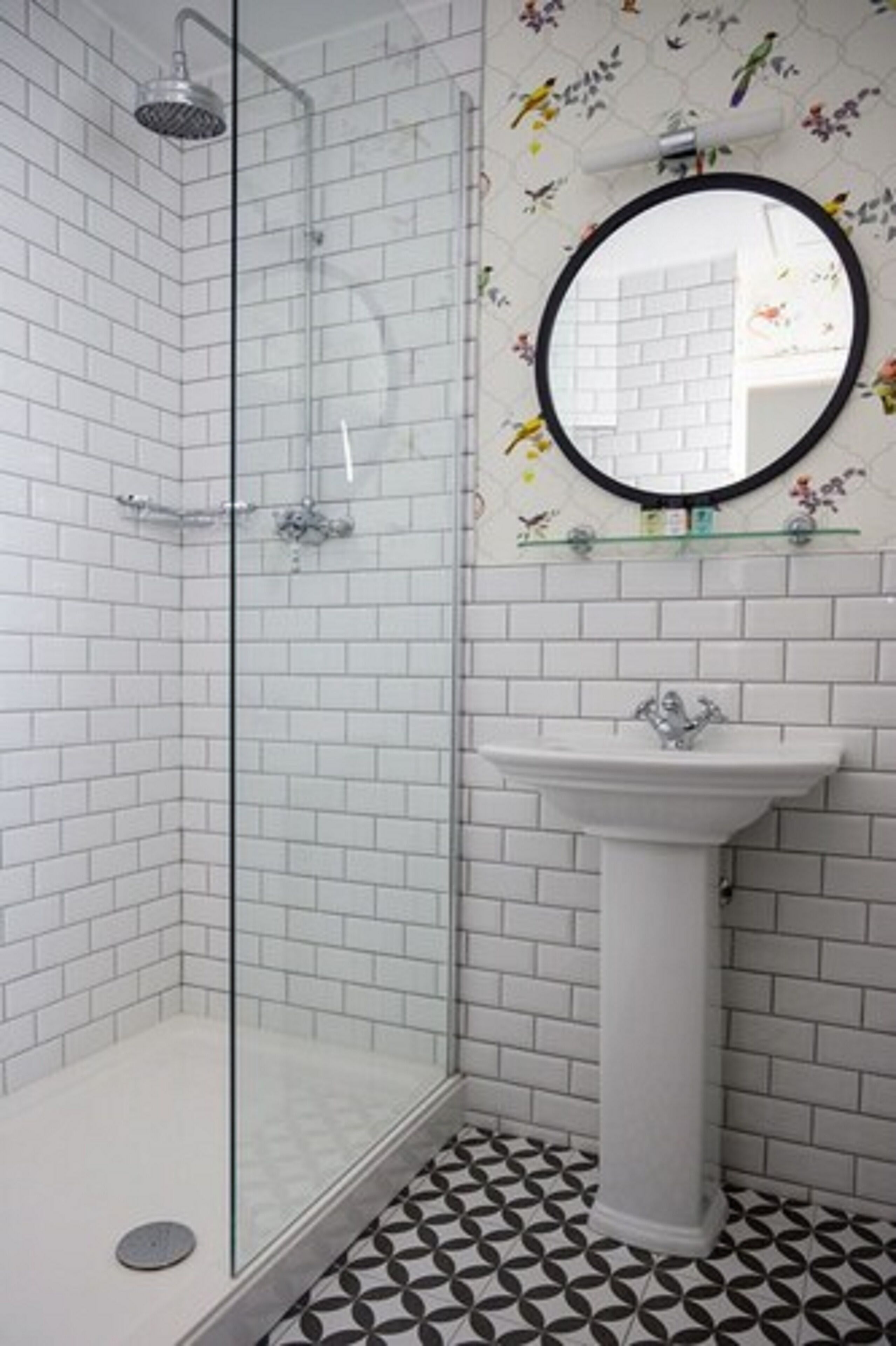 A bathroom with a shower, a sink, and a mirror.