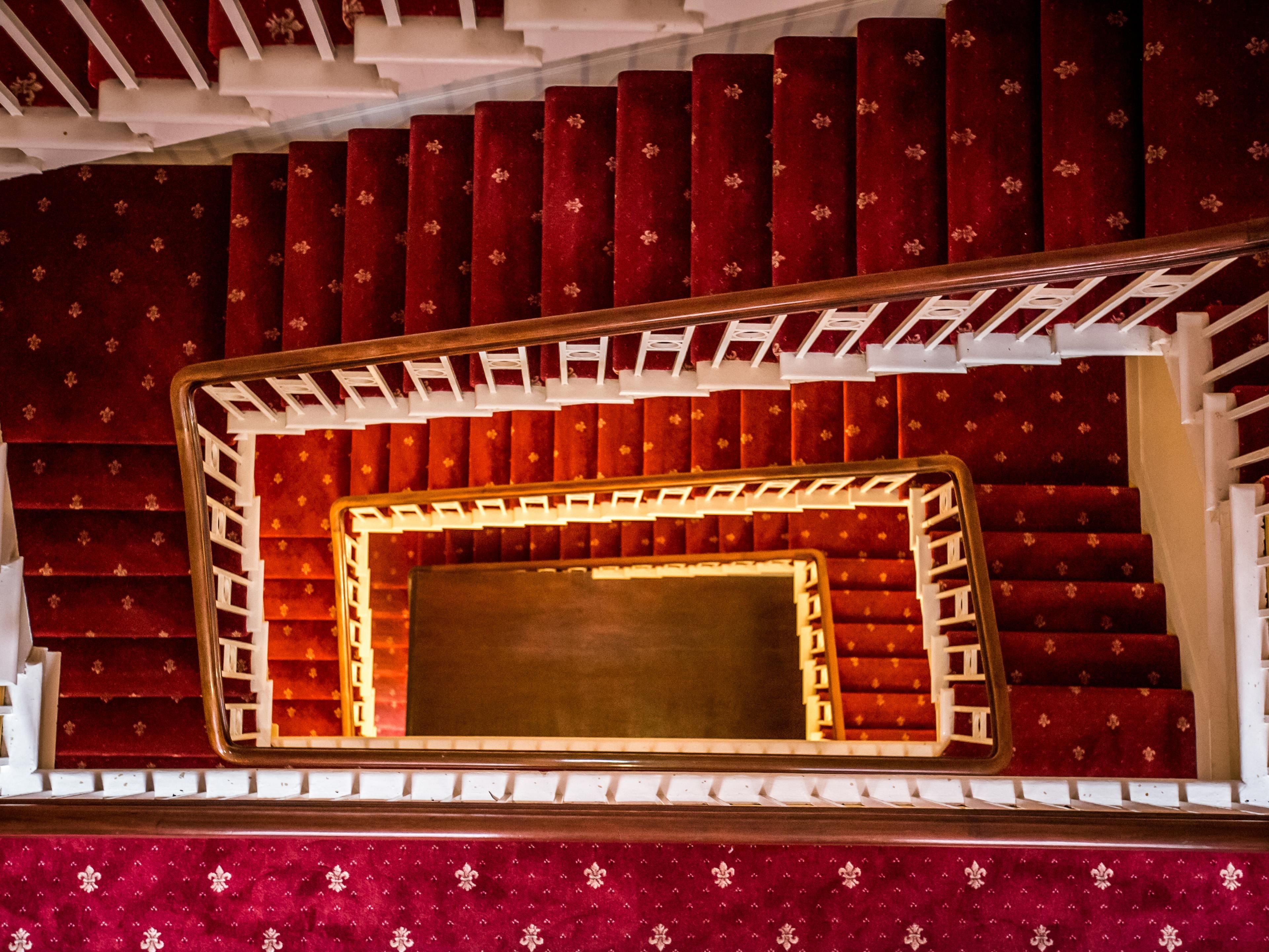 A theater with red carpeted steps and a central aisle.