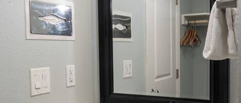 A bathroom with a large mirror, a sink, and two wall-mounted lights.