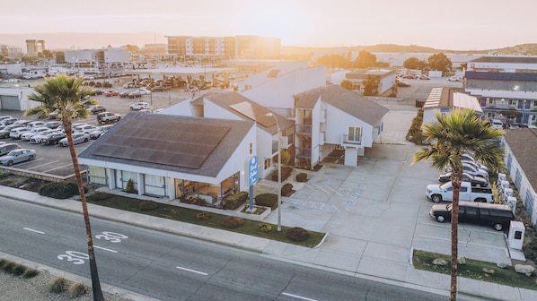 A commercial building with a parking lot, a visible storefront, and a street with a bicycle lane.
