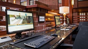 Mostrador de recepción de hotel con computadoras, teclado, ratón y una lámpara.