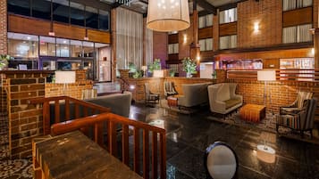 A lobby with a brick wall, a reception desk, and seating areas.