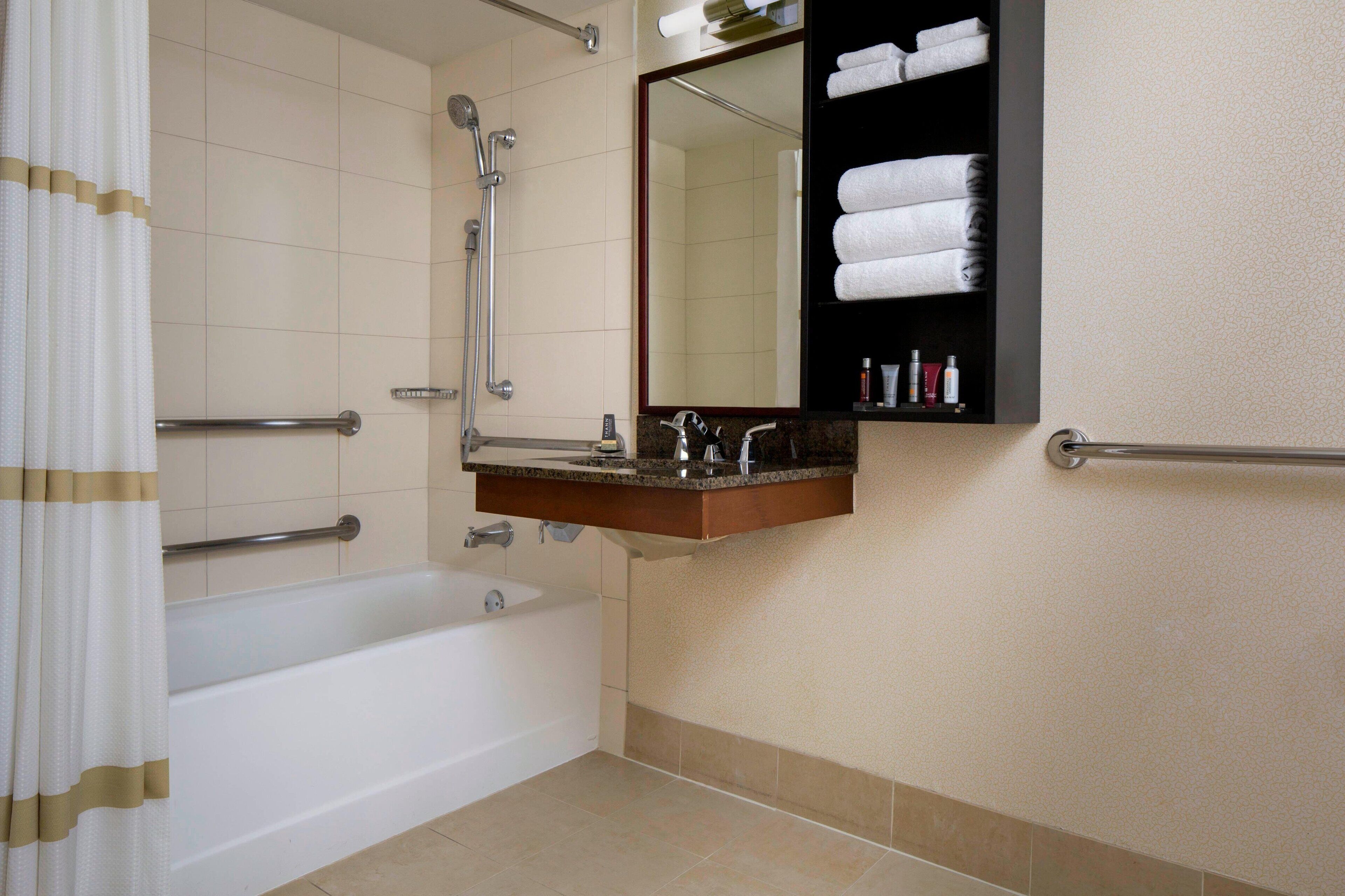combined shower/bathtub, designer toiletries, hair dryer, towels
