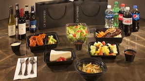 A table with various food items, drinks, and a set of black shopping bags. - Hilton Houston NASA Clear Lake (Houston)
