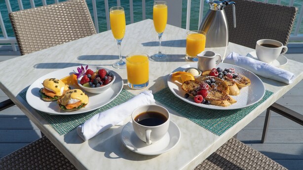 A table set with breakfast including eggs, toast, fruit, juice, coffee, and a coffee pot. - Hilton Houston NASA Clear Lake (Houston)