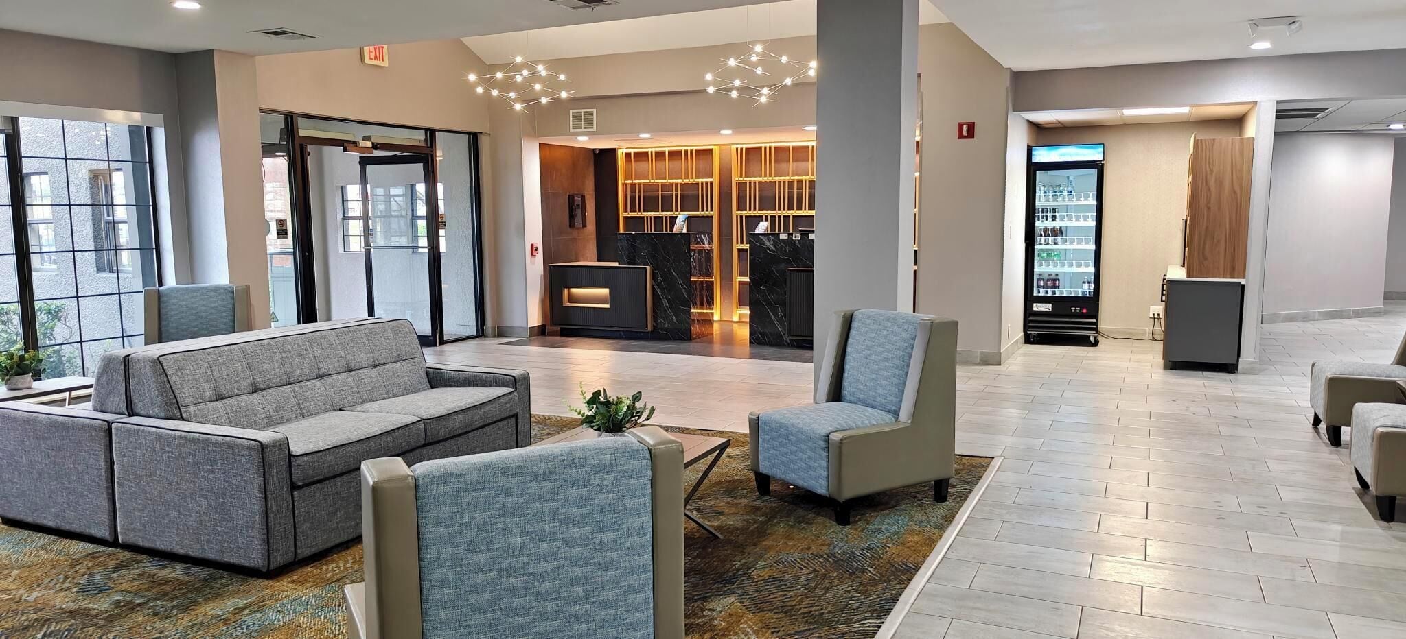A hotel lobby with a reception desk, seating area, and a vending machine.