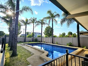Una piscina al aire libre, tumbonas