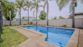 Alberca al aire libre y camastros