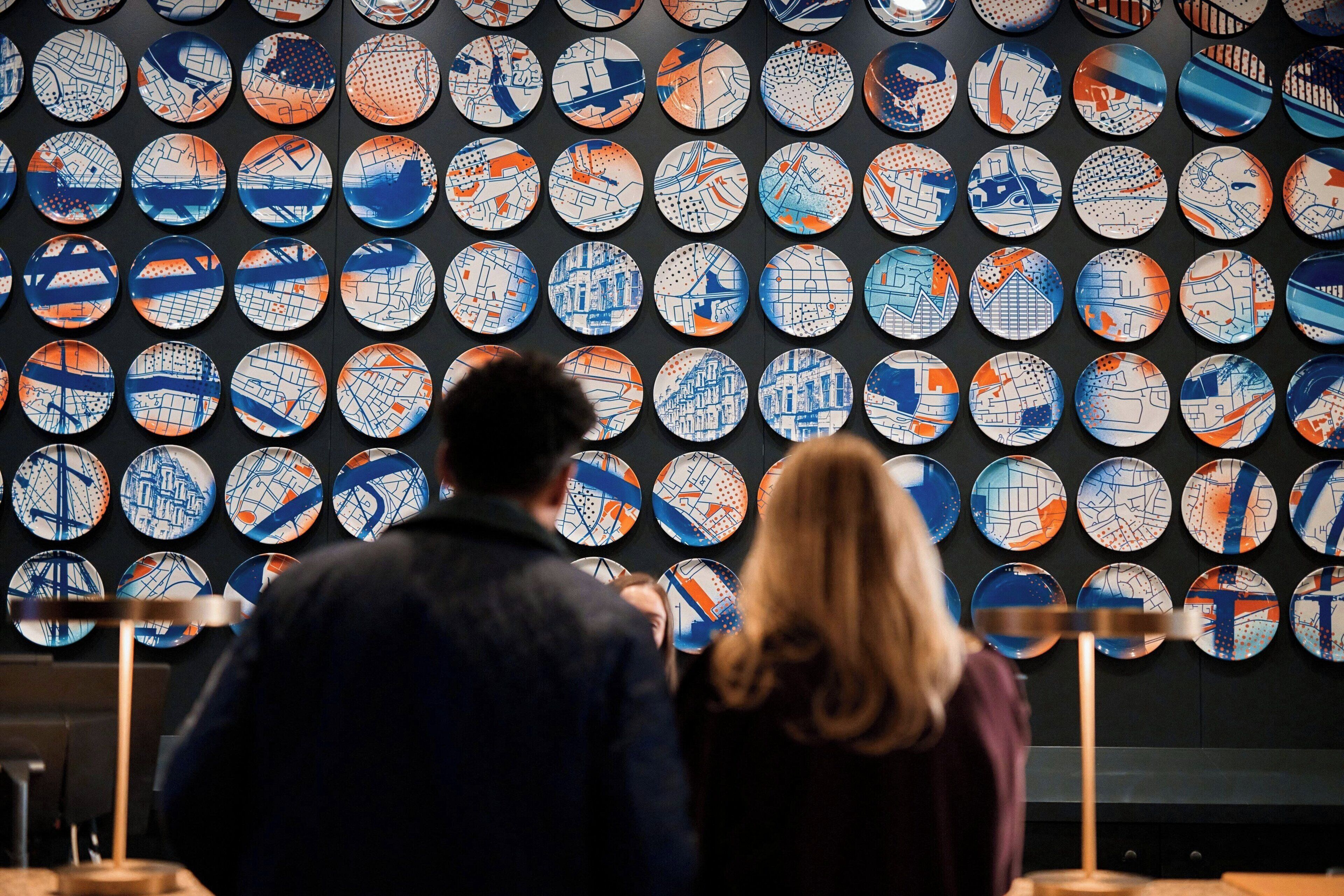A wall of circular plates with various patterns.