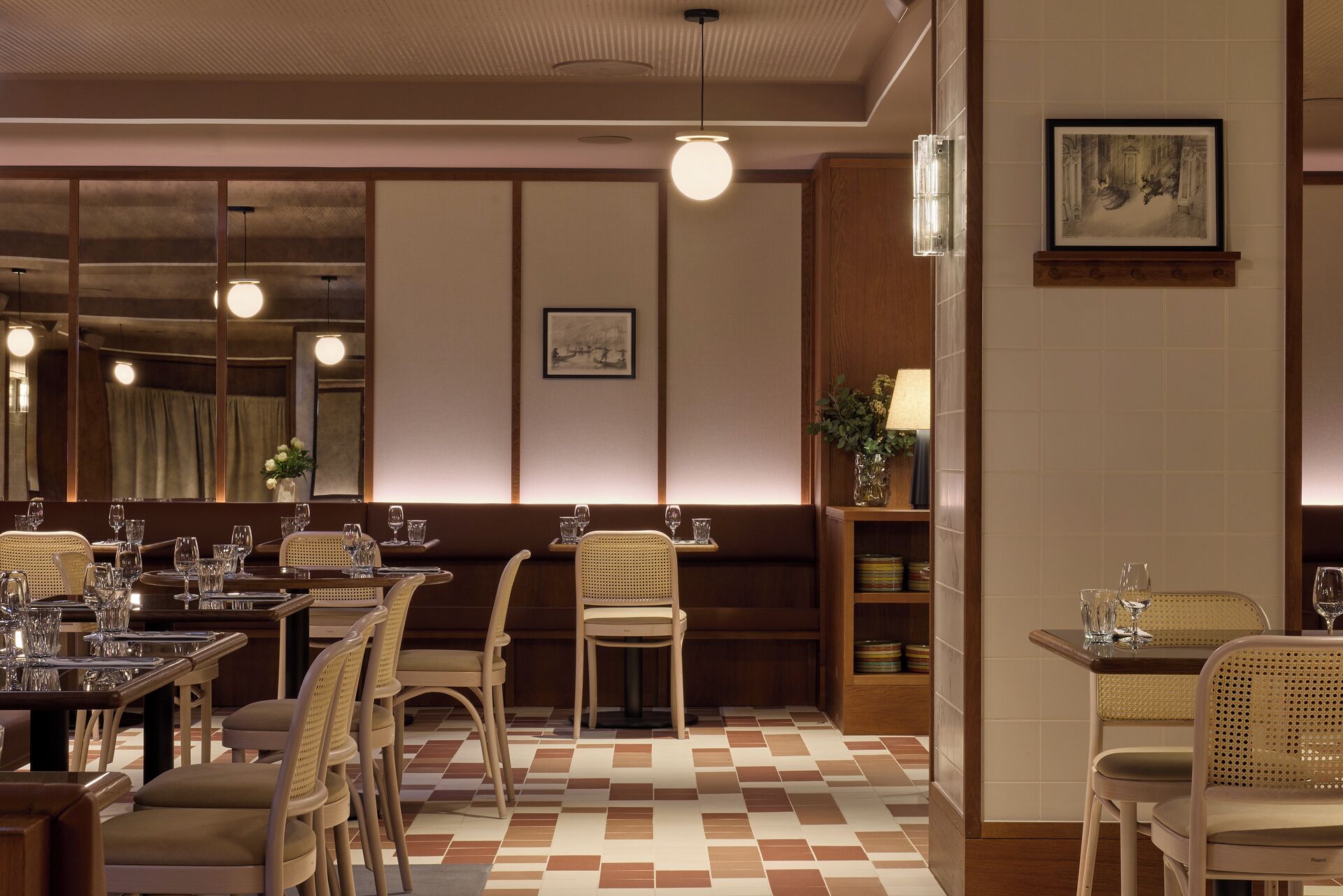 Un restaurant avec un sol à carreaux, des meubles en bois et des luminaires suspendus.
